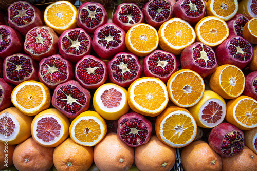 Cutted pomegranates, oranges and grapefruits on counter with street fresh juice. Red and orange fruits, front view. Real showcase with street food in Istanbul, Turkey