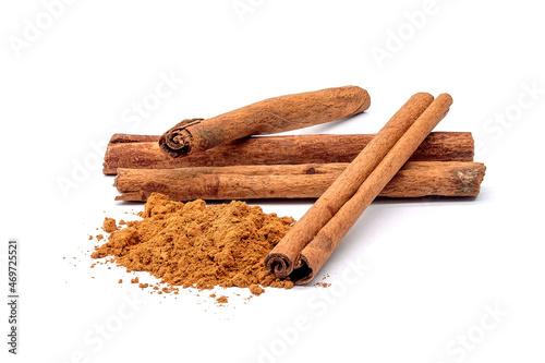 Herb, heap of dried cinnamon bark and powdered cinnamon, isolated on a white background.