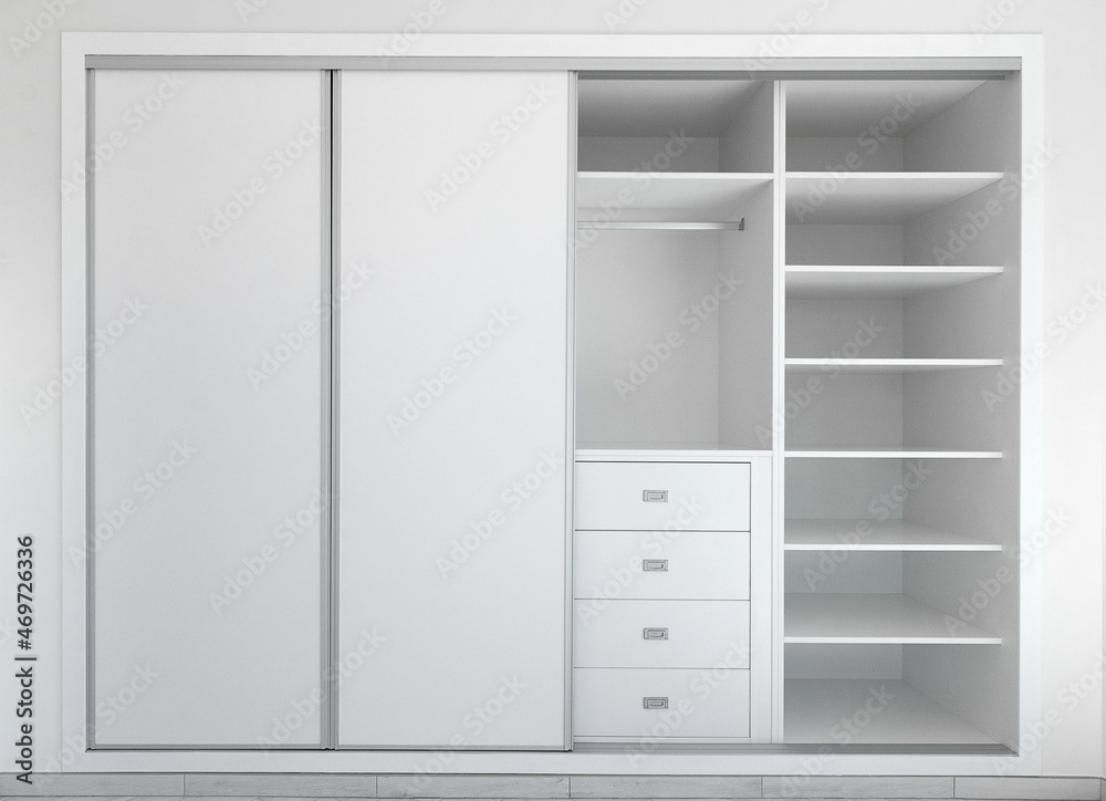 Panoramic Front view of modern empty built-in wardrobe in white. Interior design decor furnishing of luxury closet furniture. Sliding wardrobe.