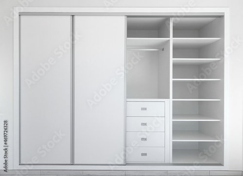 Obraz na płótnie Panoramic Front view of modern empty built-in wardrobe in white. Interior design decor furnishing of luxury closet furniture. Sliding wardrobe. w salonie