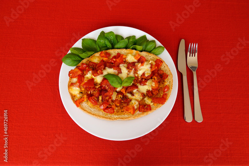 delicious large Italian bruschetta with mozzarella, garlic, olive oil and basil leaves on a plate 