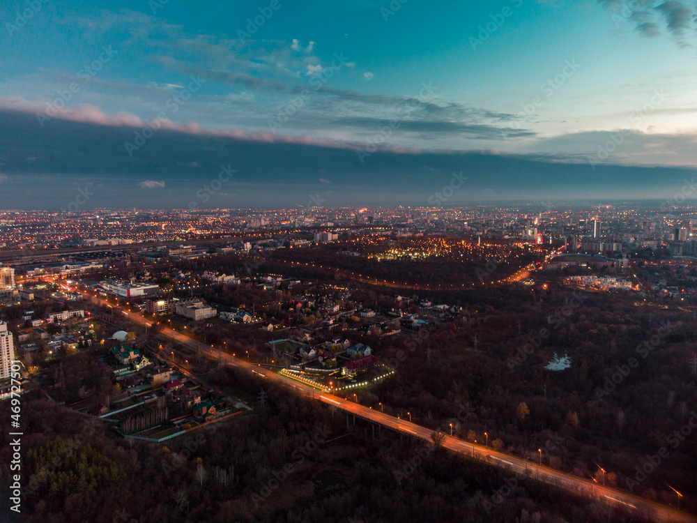 Aerial evening view on Kharkiv city center streets with night lights near recreation park Sarzhyn Yar. Residential district, scenic sunset view with epic blue skyscape