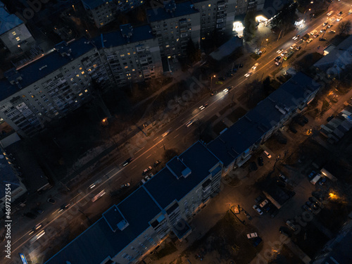 Aerial night city streets with lights illumination top flight in eastern Europe, Ukraine. Multistory buildings scenic dark view. Urban moody background
