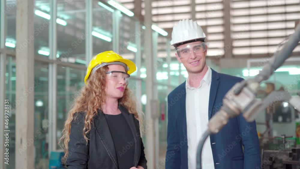 Men and women technicians discuss in a factory. Men and women technicians discuss in a factory.