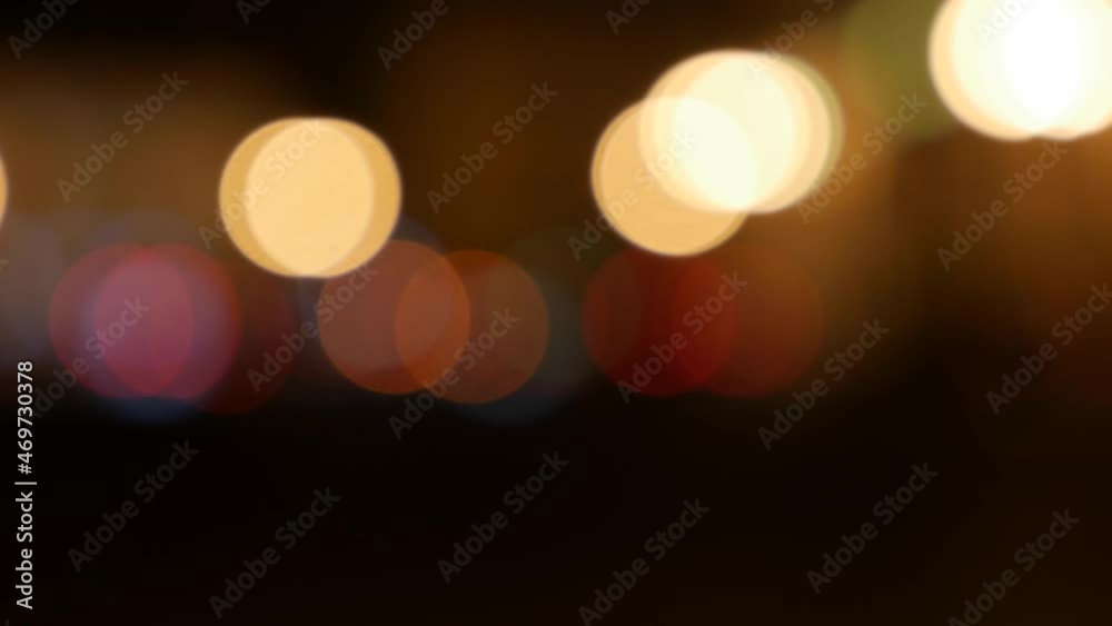 Beautiful glittering bokeh in dark blurry background at night. The round colorful bokeh shine from car lights on city street. Out of focus with blurry. Unfocused city lights. Traffic bokeh. Abstract Beautiful glittering bokeh in dark blurry background at night. The round colorful bokeh shine from car lights on city street. Out of focus with blurry. Unfocused city lights. Traffic bokeh. Abstract