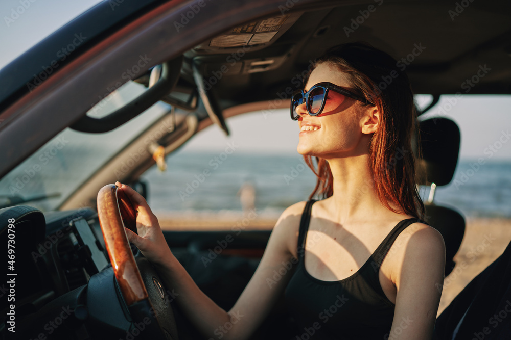 cheerful woman in sunglasses driving a car trip travel