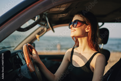 cheerful woman in sunglasses driving a car trip travel