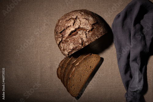 rye sliced bread and a gray towel lies on a linen tablecloth