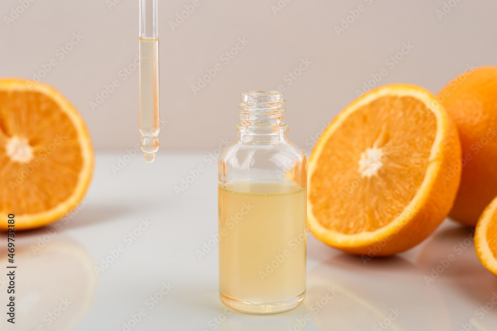 Pipette with orange essential oil over bottle and oranges. Natural medicine concept. Aromatherapy Pipette with orange essential oil over bottle and oranges. Natural medicine concept. Aromatherapy