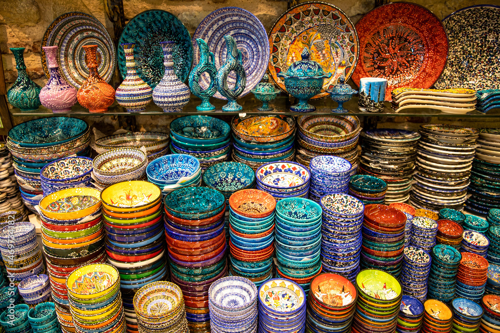 Showcase with authentic traditional oriental dishes on the market. Multicolored plates, bowls, dishes and jugs. Oriental ornaments. Grand bazaar, Istanbul, Turkey