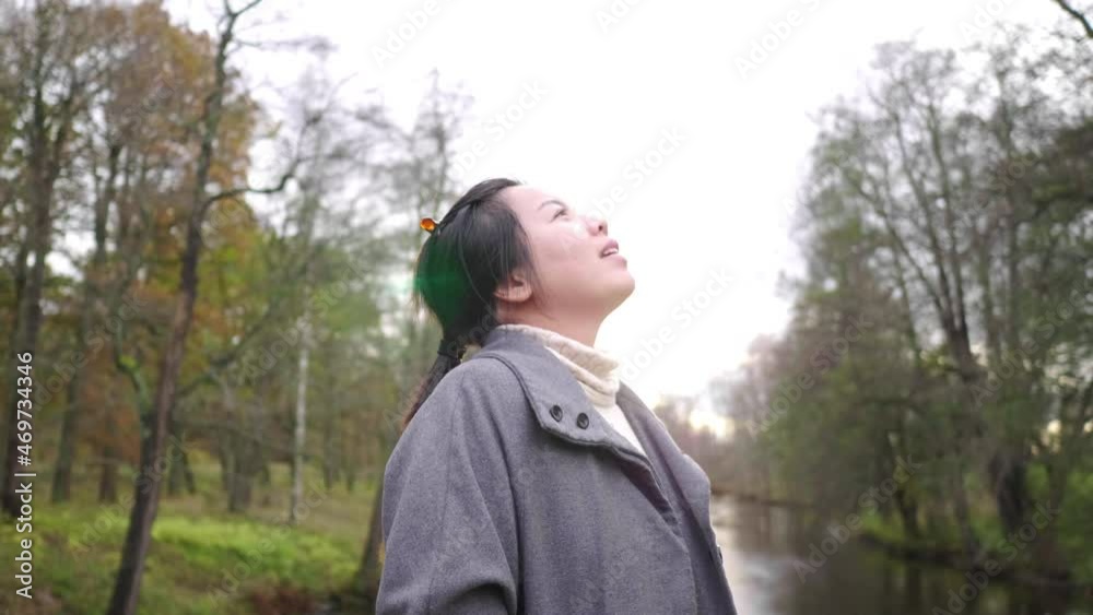 Asian woman standing, looking around and taking a deep breath in forest, Autumn season, leaves falling from the trees , beautiful nature, getting some fresh air at the park, Sweden Asian woman standing, looking around and taking a deep breath in forest, Autumn season, leaves falling from the trees , beautiful nature, getting some fresh air at the park, Sweden