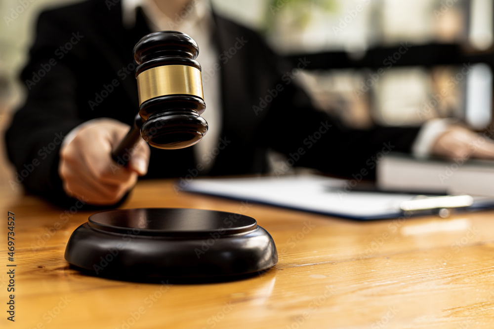A person holding the hammer of justice, the concept of a lawyer or a law enforcement officer is holding a hammer similar to the judgment of a lawsuit. A person holding the hammer of justice, the concept of a lawyer or a law enforcement officer is holding a hammer similar to the judgment of a lawsuit.