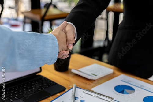 Close-up two business men holding hands, Two businessmen are agreeing on business together and shaking hands after a successful negotiation. Handshaking is a Western greeting or congratulation.