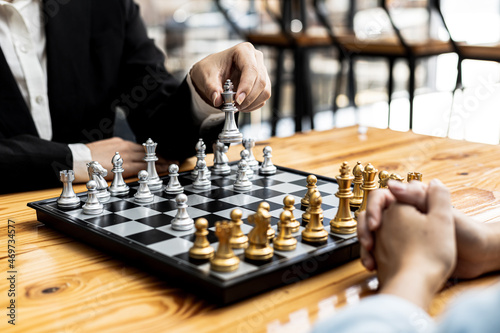 Two people playing a game of chess, concept image of two businessmen playing chess compared to a business competition that requires strategic planning and risk-based business management.