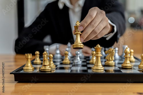 Person playing chess board game, business woman concept image holding chess pieces like business competition and risk management, planning business strategies to defeat business competitors.