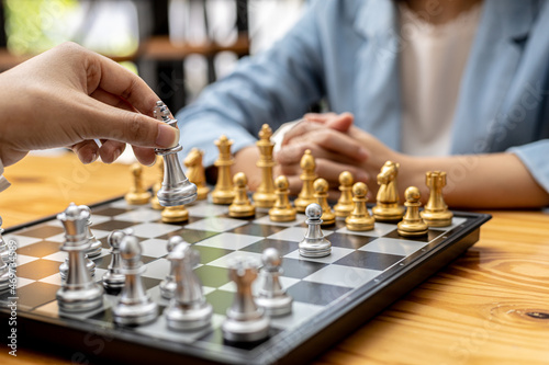 Two people playing a game of chess, concept image of two businessmen playing chess compared to a business competition that requires strategic planning and risk-based business management.
