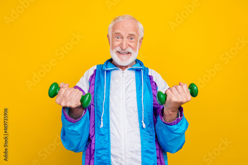 Photo of senior man bodybuilding intense regime effort old-fashioned costume isolated over yellow color background