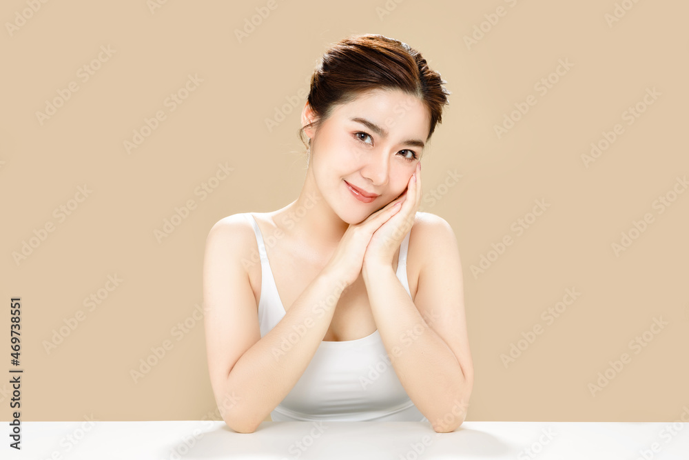 Asian woman with a beautiful face and fresh, smooth skin. Cute female model  with natural makeup and sparkling eyes is posing on white isolated  background. Stock Photo