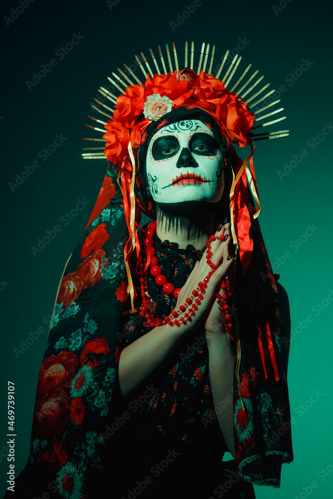 Fototapeta premium Young woman in calavera style with Mexican skull make-up on her face
