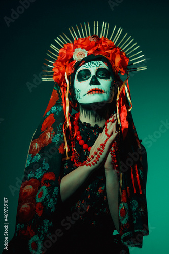 Young woman in calavera style with Mexican skull make-up on her face