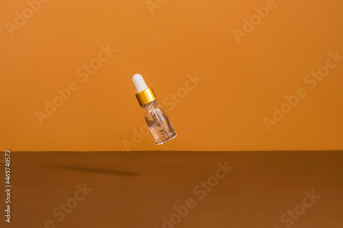 Gravity tube with cosmetic oil without a brand. Mockup style. Beauty background with facial cosmetic products. Spa, beauty concept.