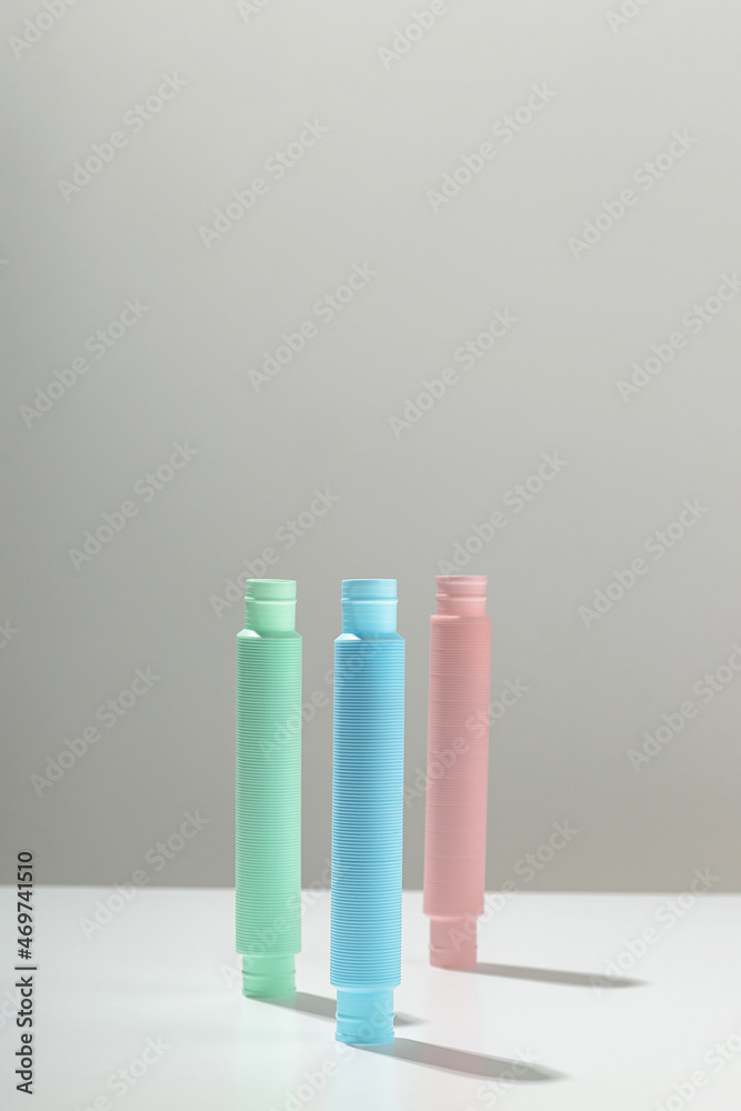 Blue purple and mint antistress pop tube toy stand upright on light background with a shadow. Kid toy pastel color. Copyspace. Blue purple and mint antistress pop tube toy stand upright on light background with a shadow. Kid toy pastel color. Copyspace.