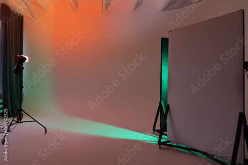 Empty photo studio with cyclorama. Monoblocks with flashes using color filters. Photo studio space with white cyclorama