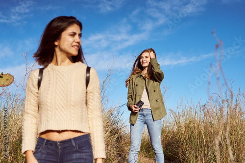 Two female friends walking in mountains looking