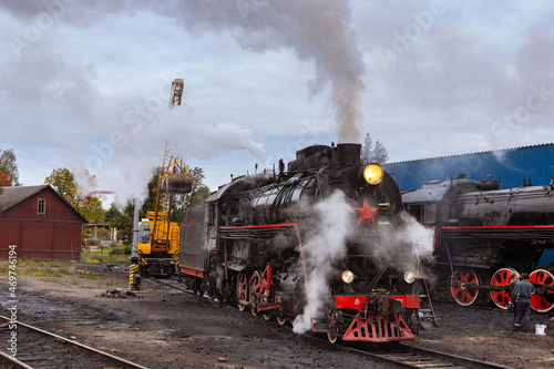 Sortavala, Karelia, Russia - September 16, 2021: Crane loads coal onto steam locomotive
