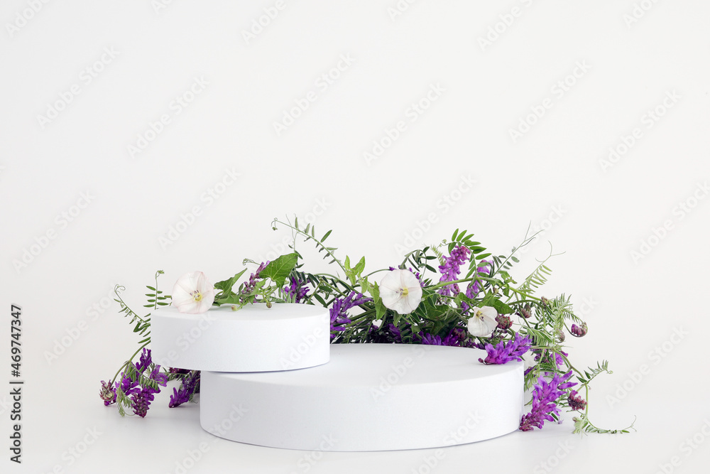 White podium on the white background with flowers. Podium for product, cosmetic presentation. Creative mock up. Pedestal or platform for beauty products. White podium on the white background with flowers. Podium for product, cosmetic presentation. Creative mock up. Pedestal or platform for beauty products.