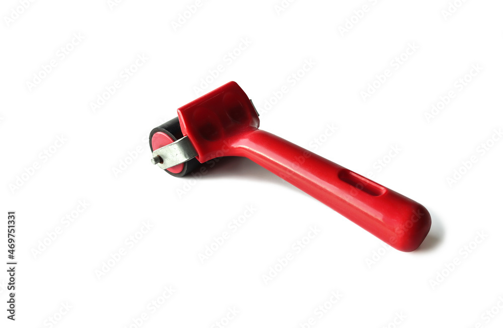 A small printing rubber roller with red handle. placed on a white background. A small printing rubber roller with red handle. placed on a white background.