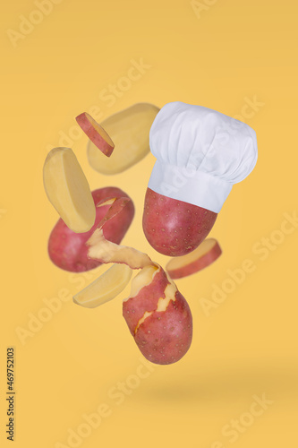 Fresh raw sliced potato flying in air isolated on yellow background.