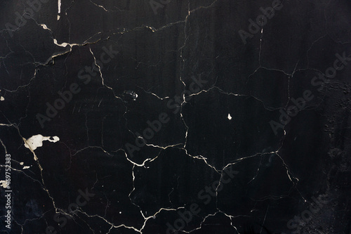 Black background with cracked surface. Cracks in the shape of a web. Cement base of wall texture.
