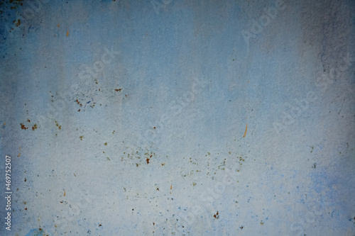 A sheet of grunge metal painted blue. Faded and weathered background.