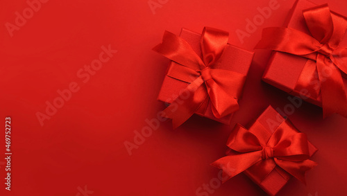 Red background with gift boxes, ribbons, bows. Preparation for holidays. Christmas, Valentines day, birthday, New Year concept. Top view