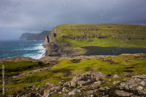 A classic landscape image of sea cliffs and a lake on the Faroe Islands