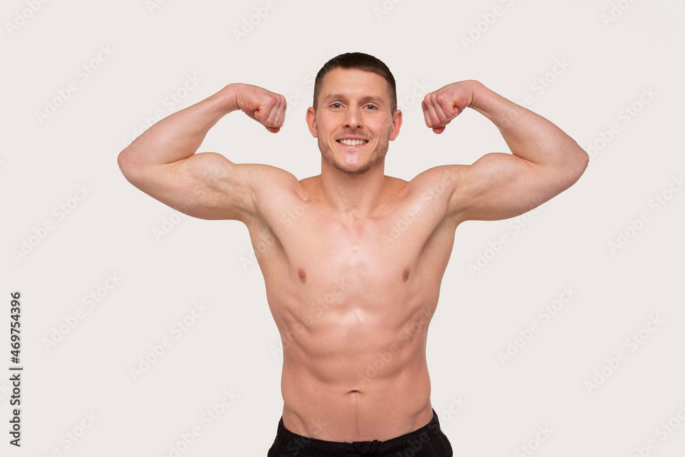 Man Showing Biceps Hands Up. Sportsman Showing Muscles. ABS, Biceps Muscles. Man Isolated