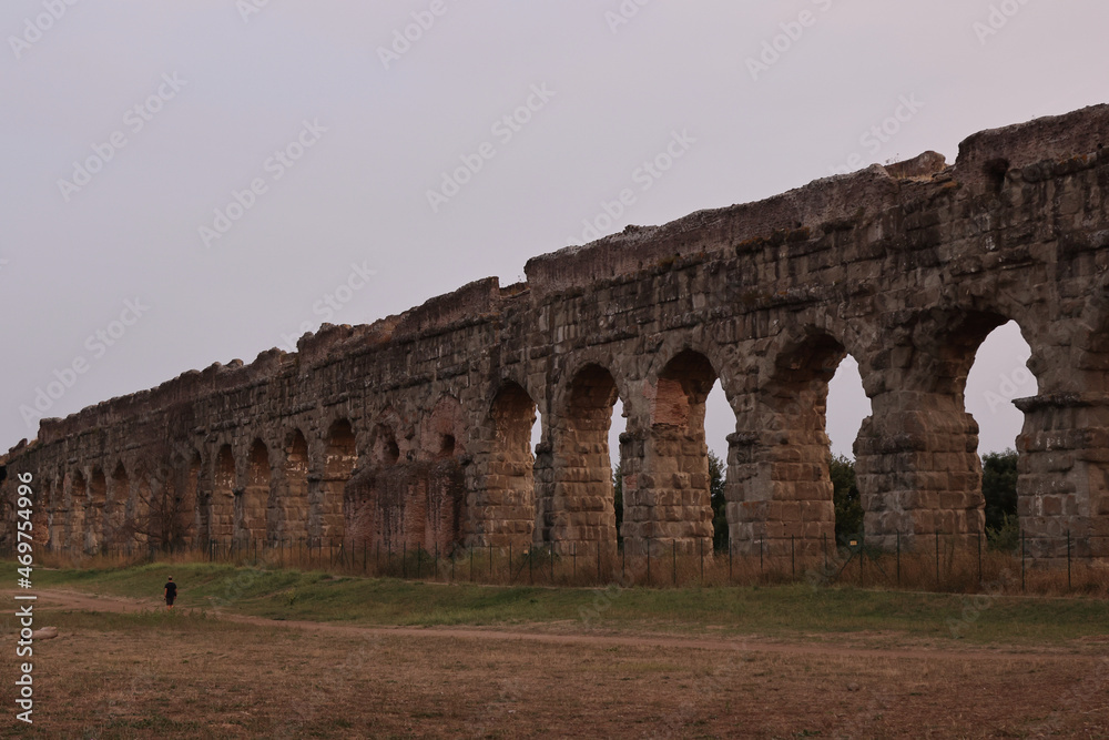 Ruins at the park of the aqueducts in Rome at sunset, Italy