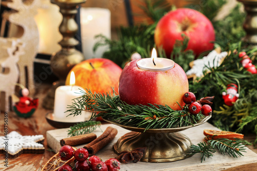 Traditional Christmas decoration with apples, cinnamon sticks and candles. photo