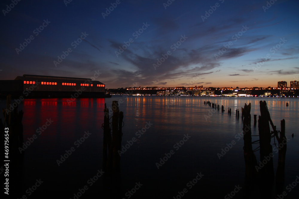 Obraz premium The red lighted pier and the river during the sunset