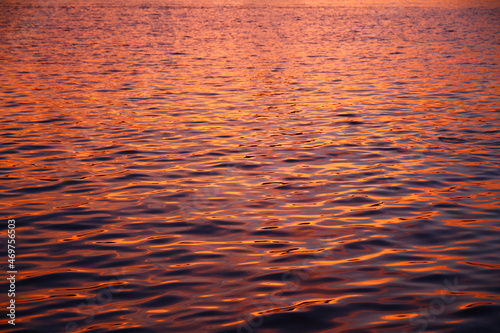 Close up of purple waves in a pattern water during a summer sunset