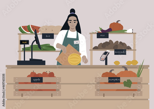 A young female Asian cashier at the farmers market, fruits and vegetables in wooden crates