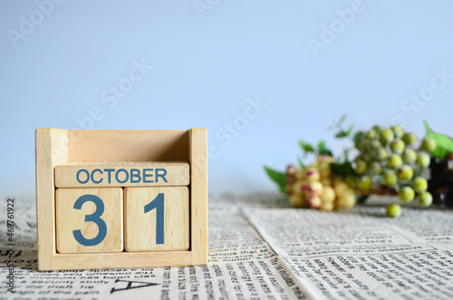 October 31, Calendar cover design with number cube with fruit on newspaper fabric and blue background.