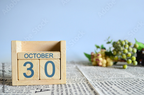 October 30, Calendar cover design with number cube with fruit on newspaper fabric and blue background.