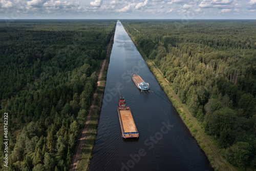 Fotografie, Obraz Aerial view of two barges diverging along a narrow channel in opposite direction