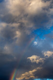 Cloudscape in a vertical orientation with a rainbow and dramatic clouds