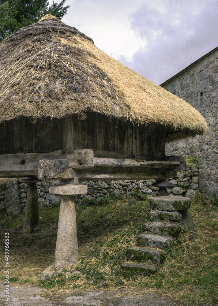 An old wooden granary with stone pillars and stairs and thatched roof An old wooden granary with stone pillars and stairs and thatched roof