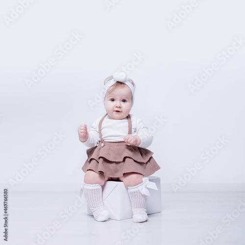 A beautiful, elegant girl received a gift. In a bright studio, a child plays and opens a gift..A picture of baby girl with big gift box