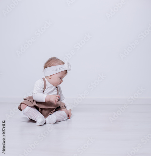 The girl is beautiful and elegant in a bright studio playing and watching