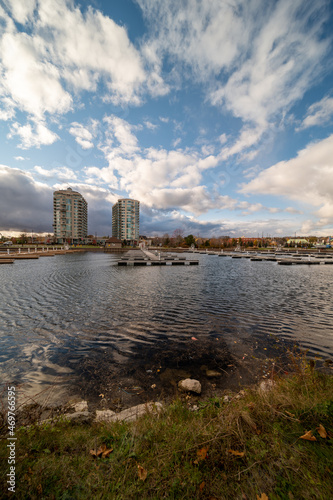 Barrie waterfront centennial park lakeshore path with green grass and fall colour trees blue sky with broken clouds 